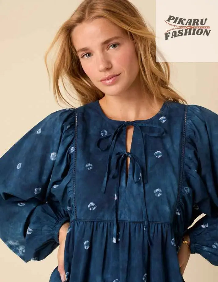 Woman wearing a blue boho dress with balloon sleeves and tie front detail