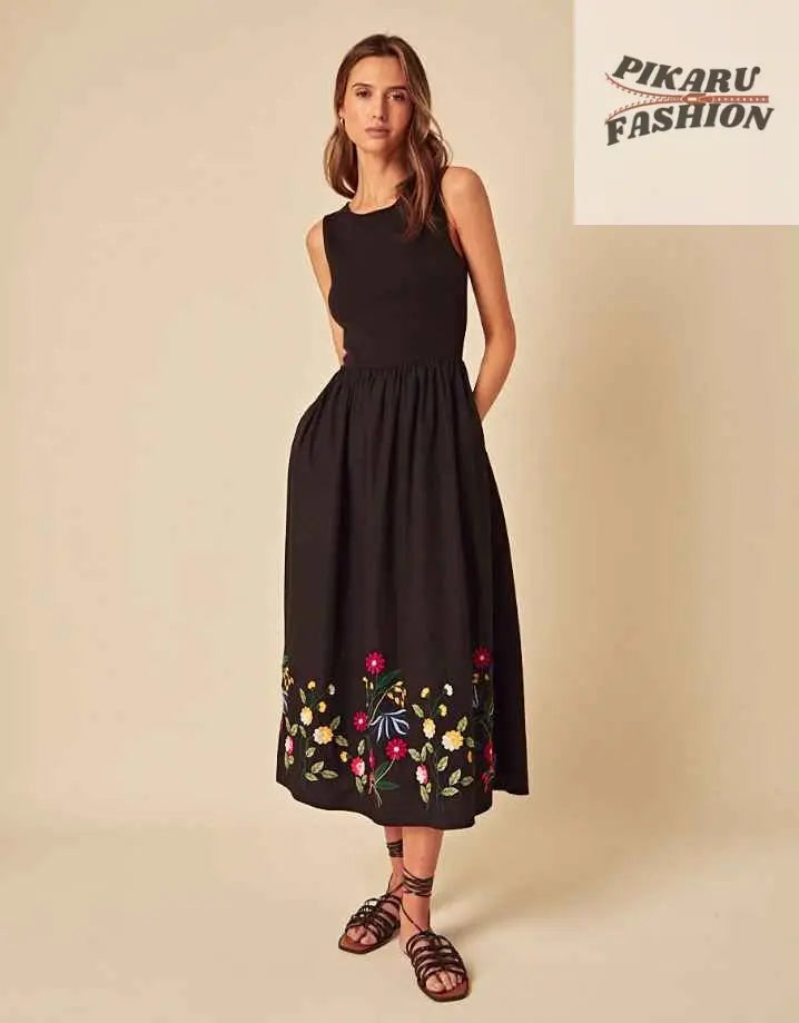 Woman wearing sleeveless black midi dress with floral embroidery, summer fashion