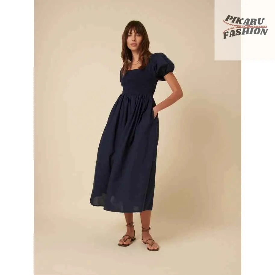 Woman in navy puff sleeve midi dress with square neckline and sandals