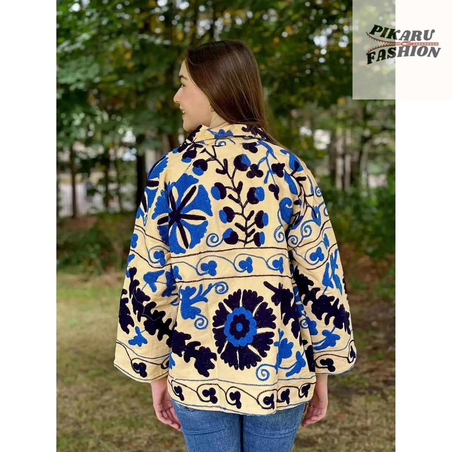 Blue Suzani embroidered jacket shown from the back on a model outdoors