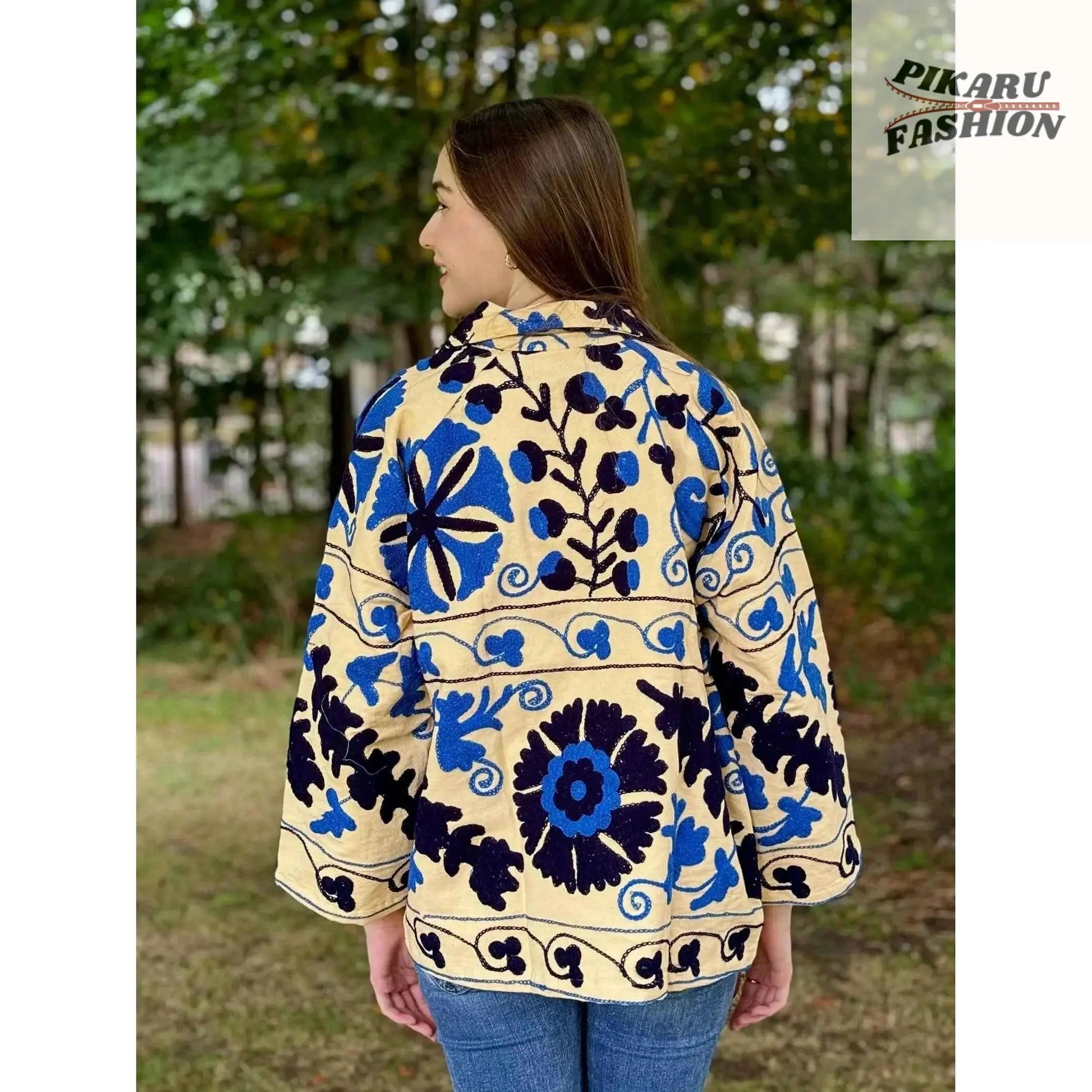 Blue Suzani embroidered jacket shown from the back on a model outdoors